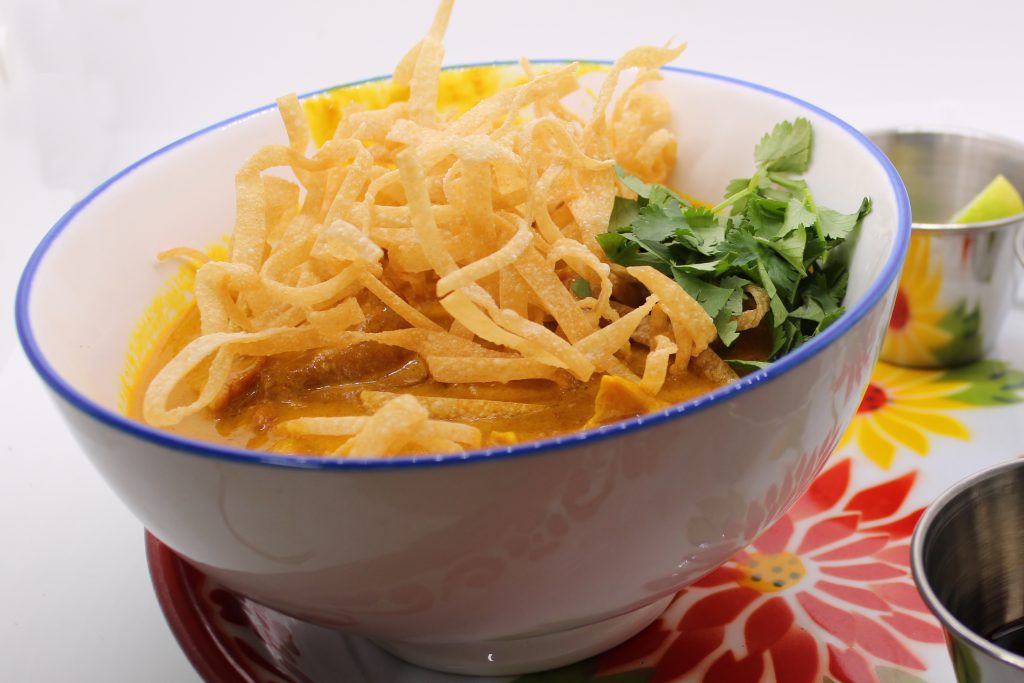 Northern Thai chicken curry. Rich, creamy, and packed with uncompromising flavor from a slew of aromatics. Topped with shallots, cilantro, pickled mustard greens, lime and crispy noodles.